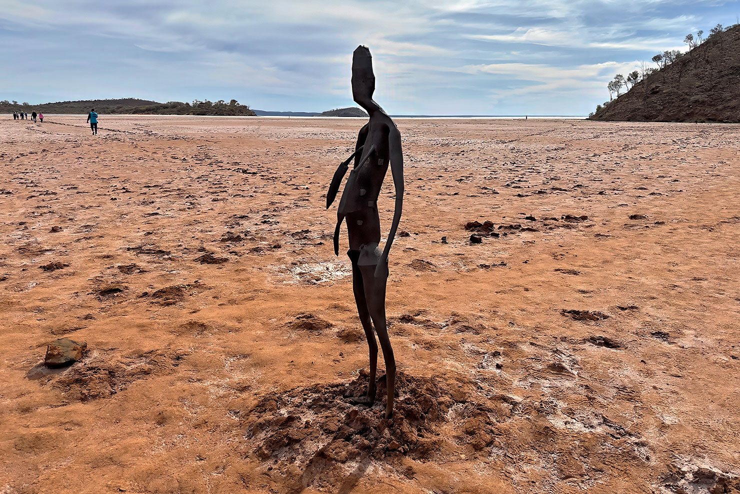 People walk across the slippery lake bed and salt flats to view the sculptures of Antony Gormley