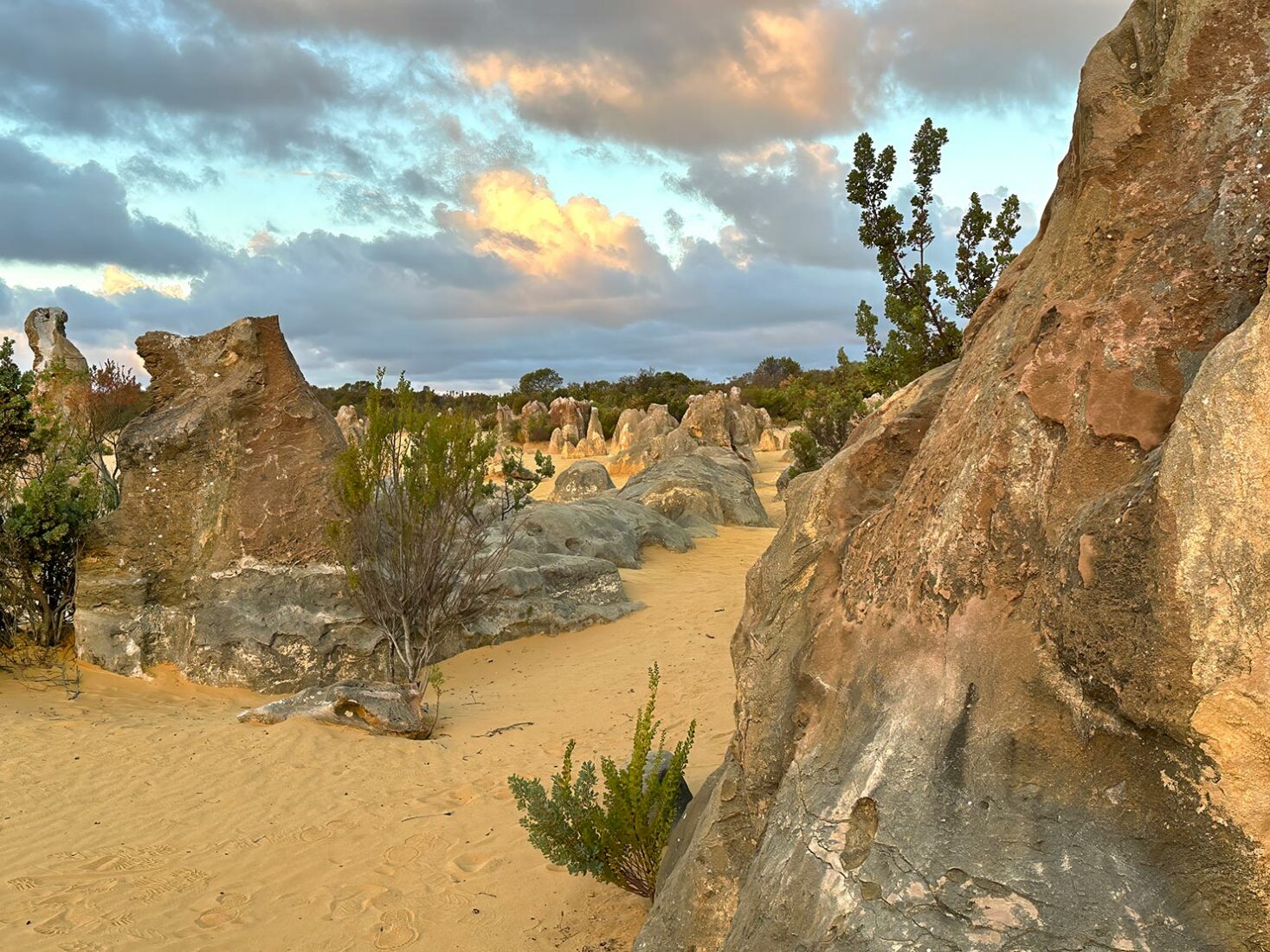 The sun begins to set in the lat4e afternoon, painting the sand and rock formations in richer hues